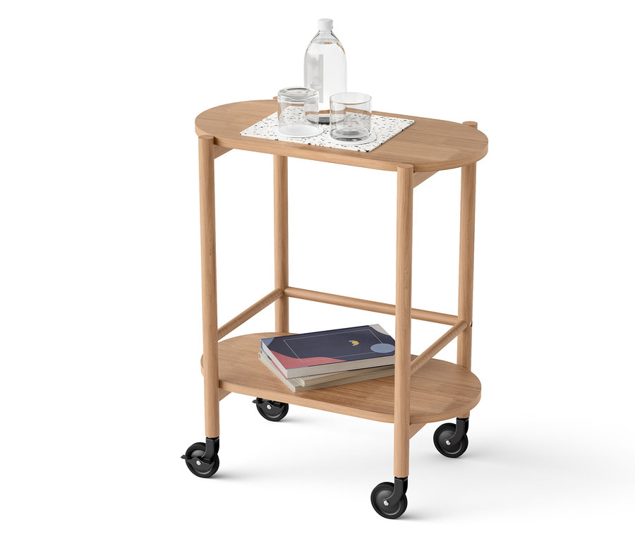 Na dvojpodlažnom vozíku stojí fľaša vody, poháre a knihy.