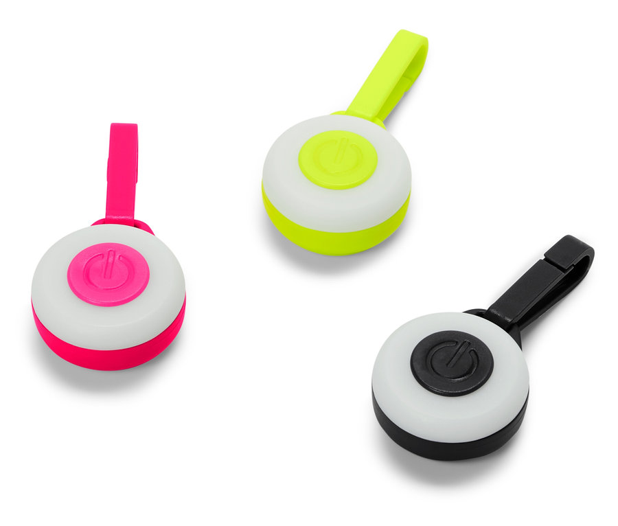 Tri okrúhle svetlá s klipmi v ružovej, zelenej a čiernej farbe.