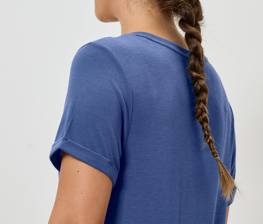 Žena so zapleteným vrkočom má na sebe modré tričko.