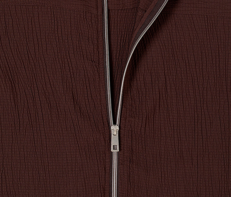 Detail záberu rozopnutej bundy CECIL v tmavohnedej farbe so strieborným zipsom.