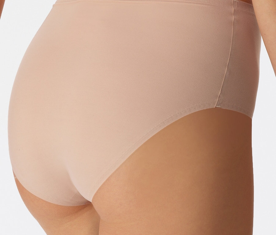 Detailný záber na zadnú časť ženy v spodnej bielizni telovej farby.