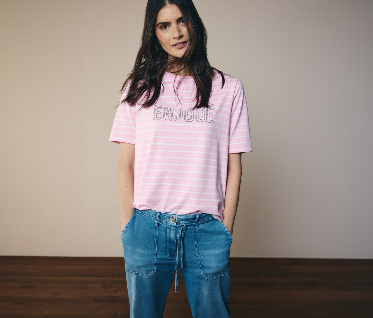 Žena v džínsoch a ružovo-bielom tričku CECIL s nápisom ENJOUE.