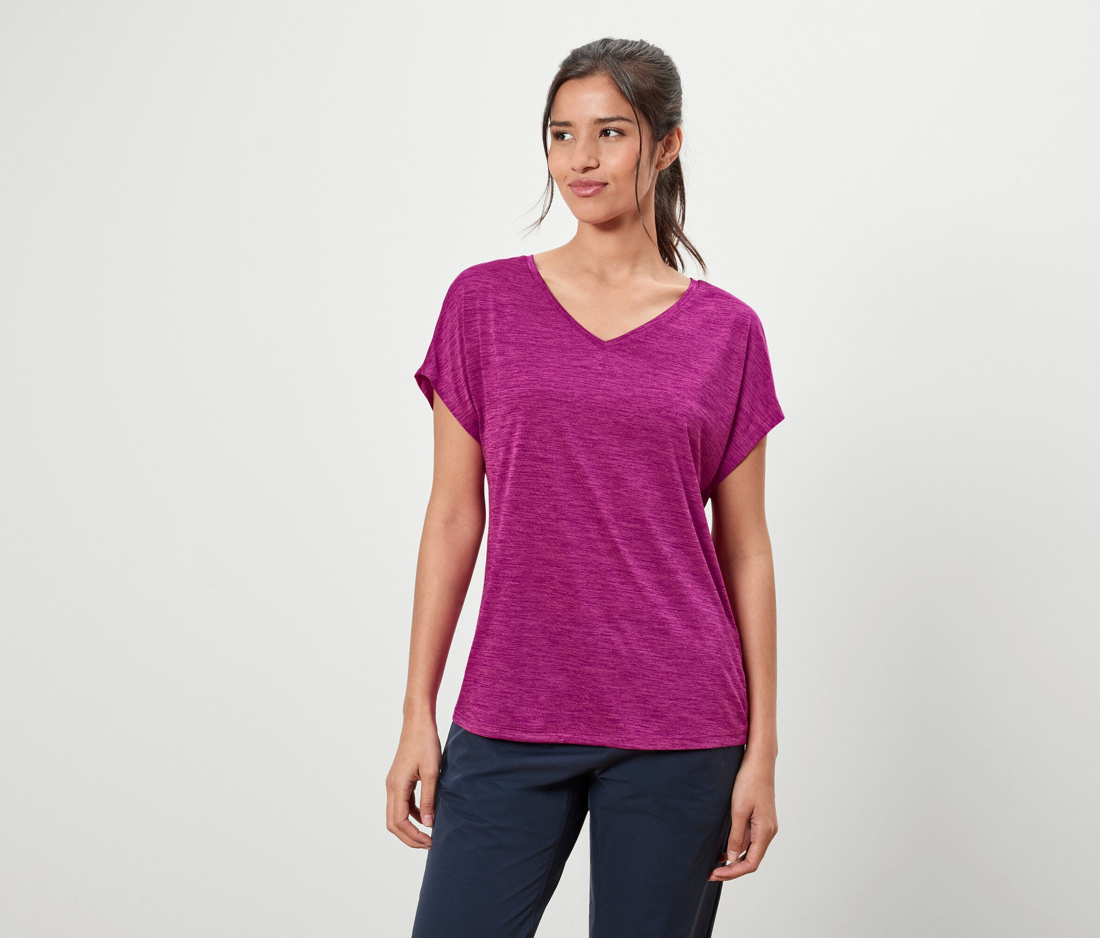 Žena má na sebe fialové tričko a modré nohavice.