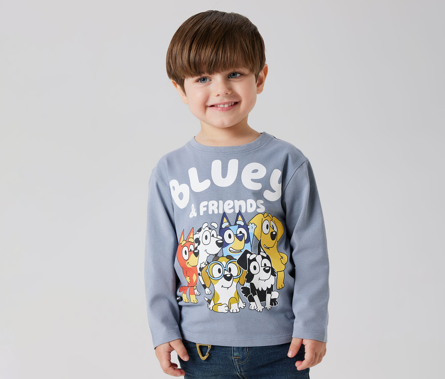 Usmievavý chlapec má na sebe detské tričko s dlhým rukávom NAME IT »BLUEY« s motívom Bluey a priateľov.