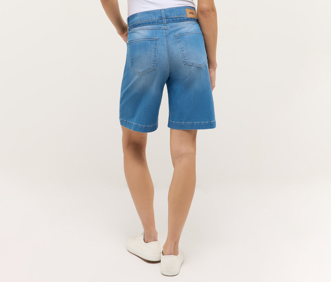 Pohľad zozadu na ženu v svetlomodrých šortkách Angels Denim »Lia City« a bielych topánkach.