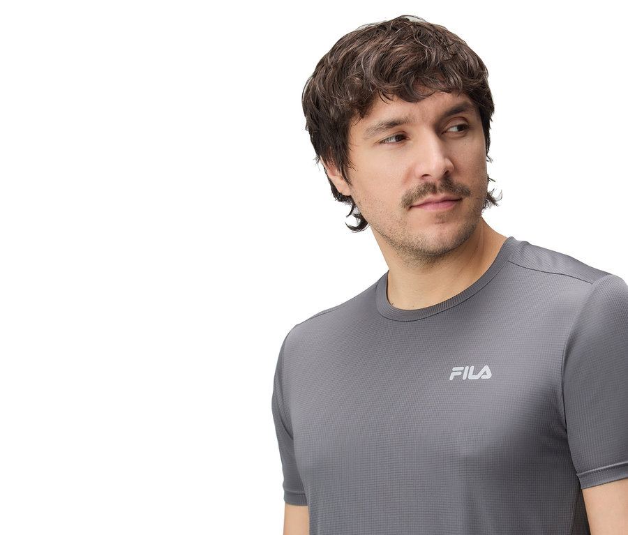 Muž má na sebe sivé tričko Fila.