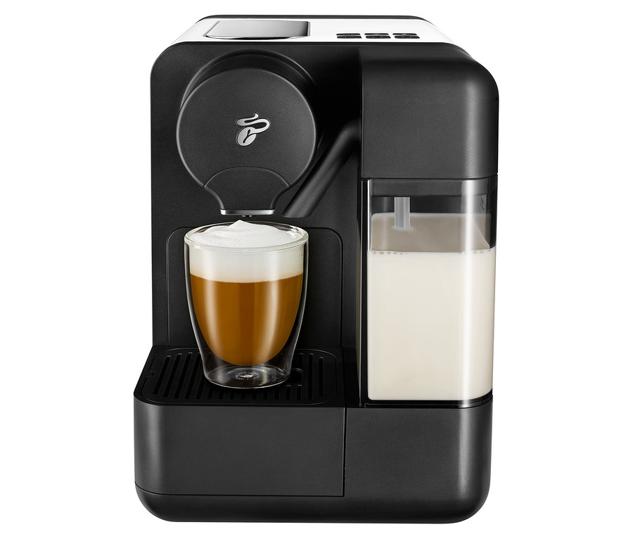 Čierny kávovar s bielym mliekom Cafissimo a pohárom naplneným kávou.