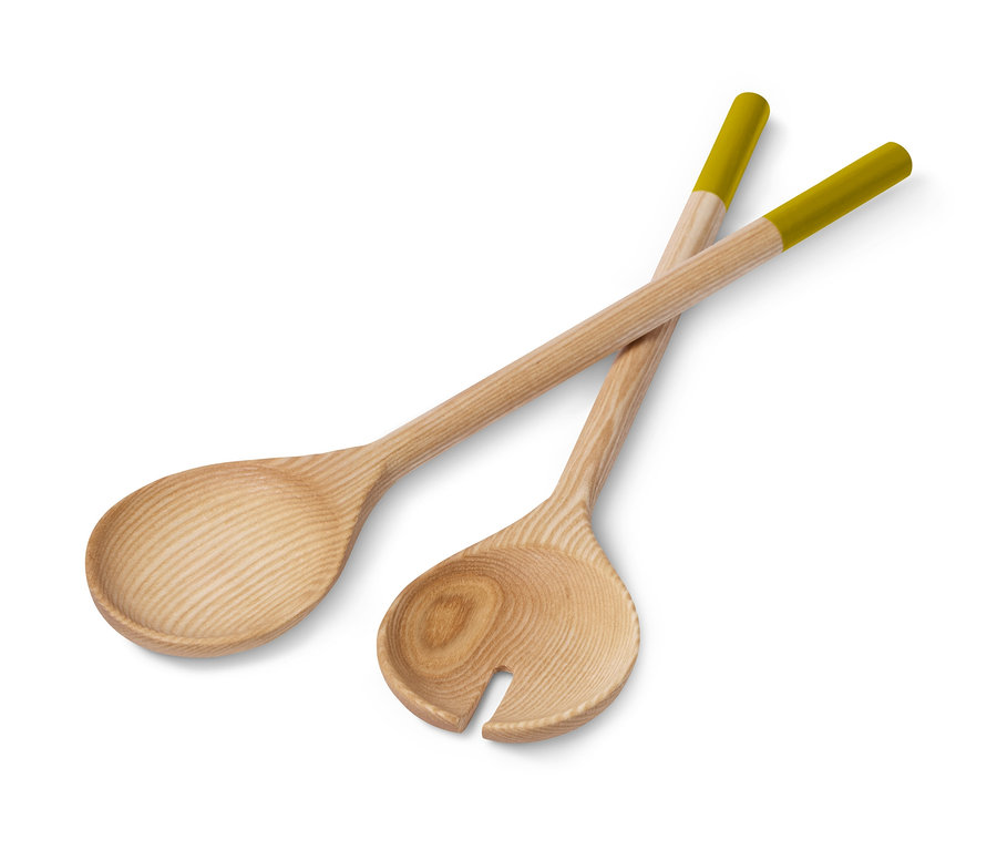 Dva drevené príbory na šalát s olivovo zelenými koncami ležia prekrížené na bielom pozadí.