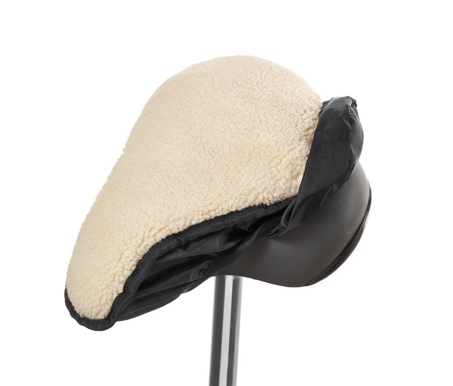 Detailný záber na poťah na sedadlo bicykla 2 v 1 s béžovou jahňacou kožou a čiernym nylonovým okrajom.