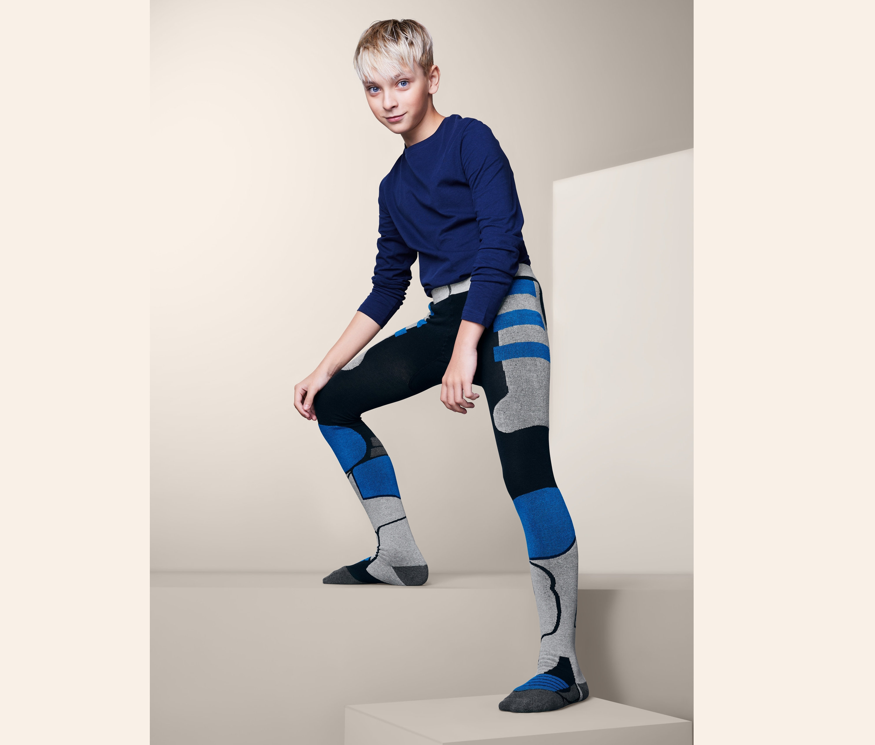 Mladík pózuje v lyžiarskych pančuchových nohaviciach.