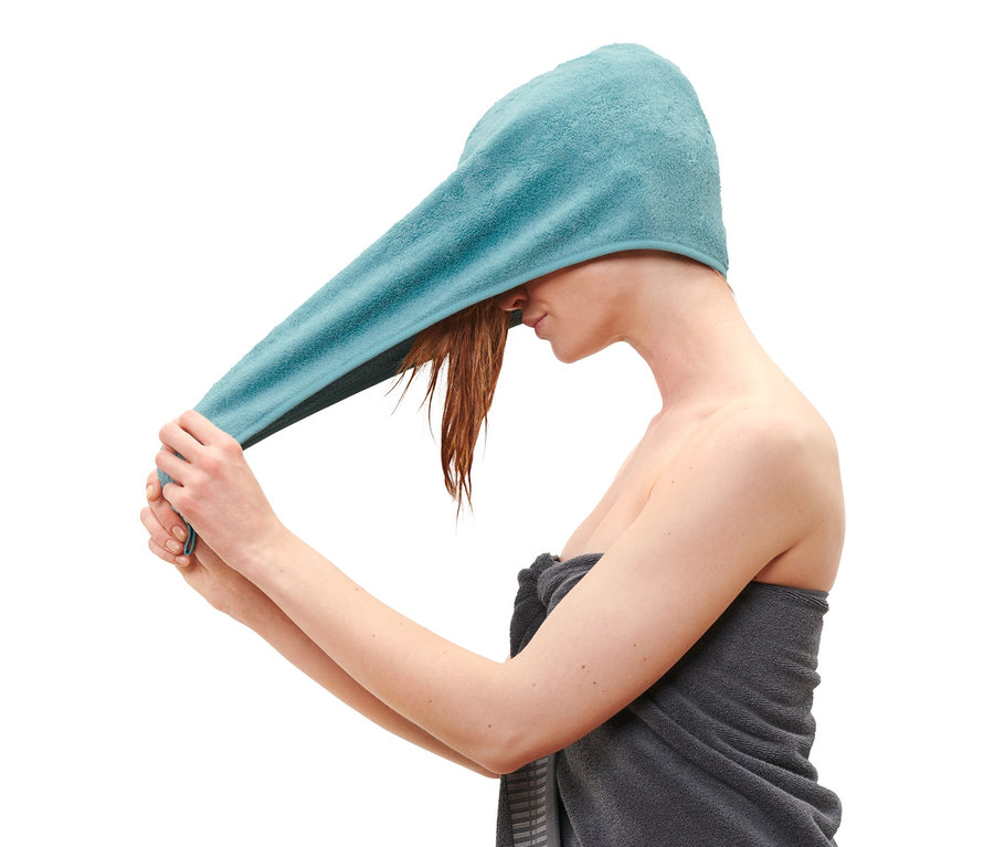 Žena si dáva na hlavu akvamarínový uterákový turban.
