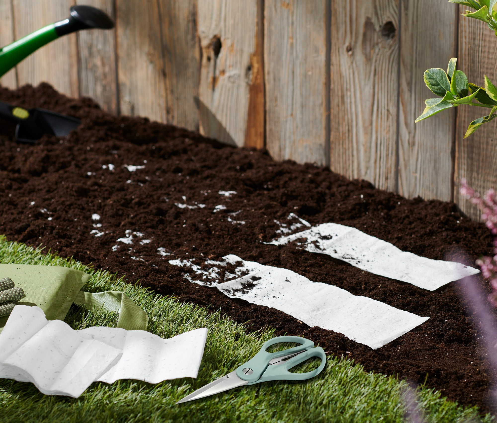 Záhradné náradie a kvetinové koberce Včelia lúka na trávniku pri hline.