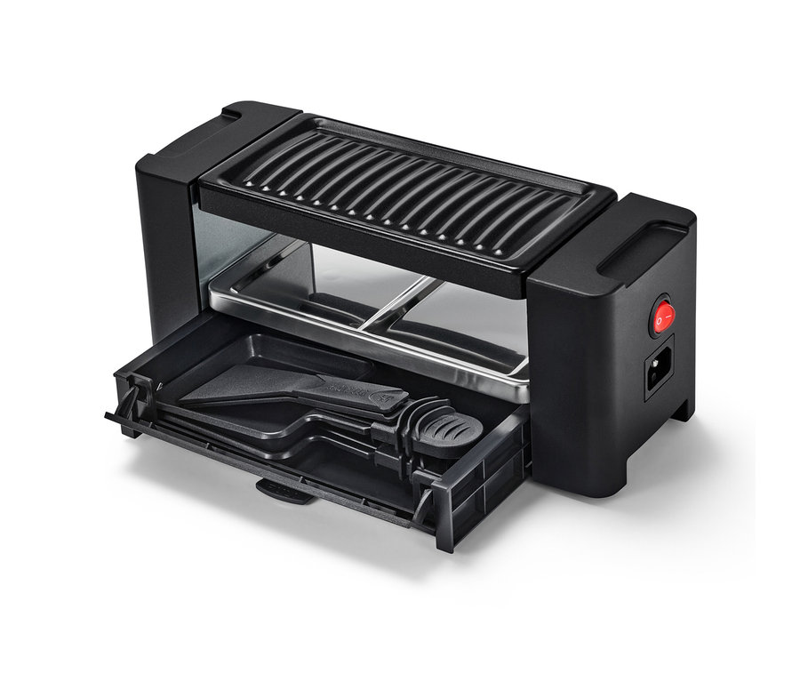 Čierny raclette set pre dvoch s vysunutou zásuvkou s príslušenstvom.