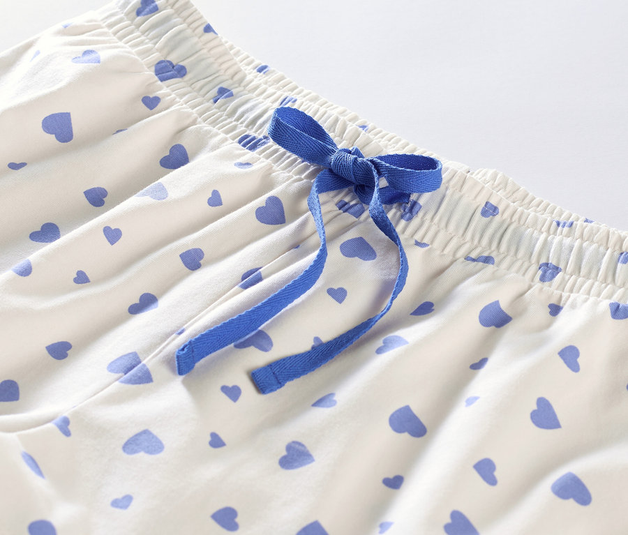 Detail krátkeho pyžama so srdiečkami a modrou stuhou.