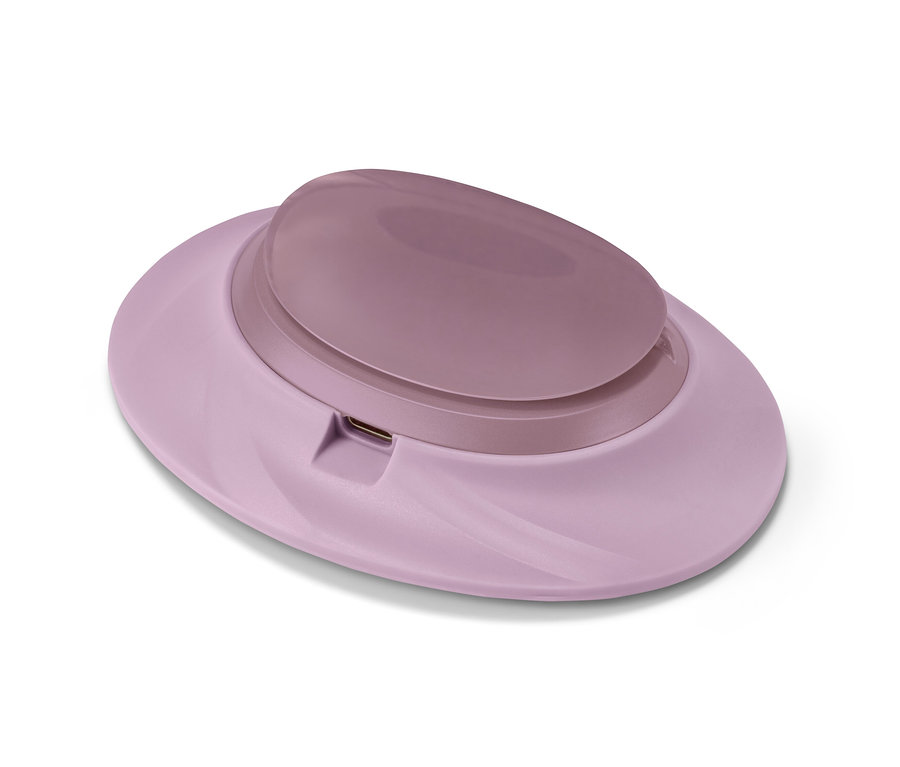 Svetloružový akumulátorový ohrievač brucha na bielom pozadí.