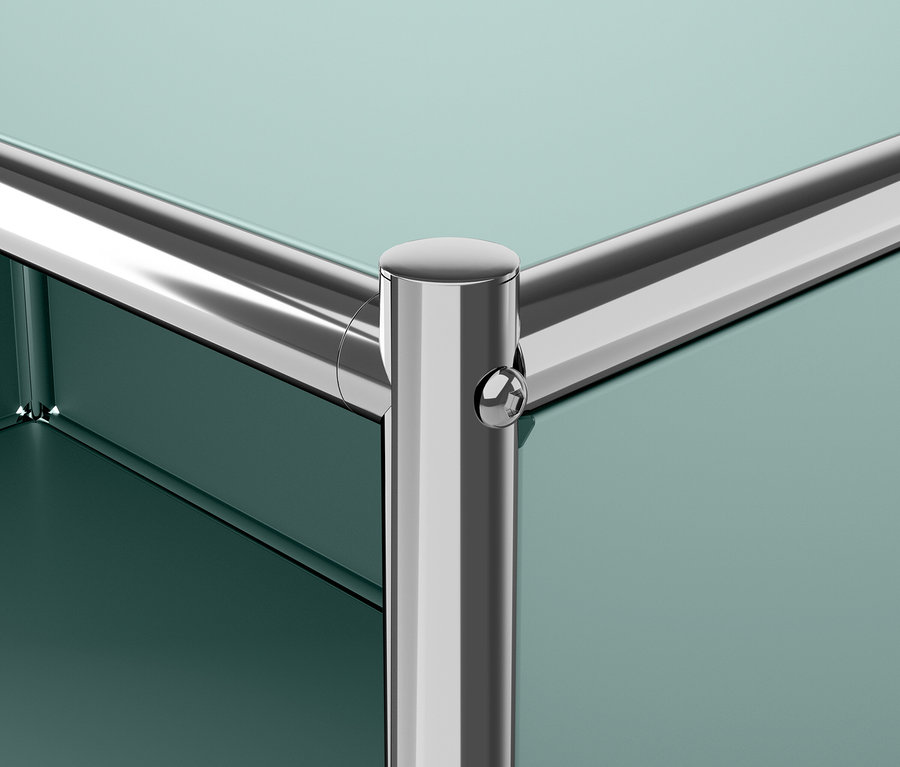 Detail rohu zelenej police s chrómovaným rámom.