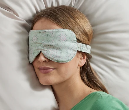 Žena spí s maskou na spanie.