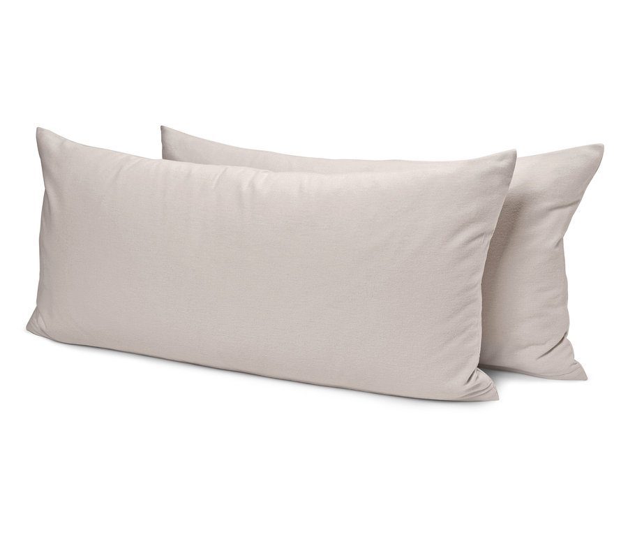 Dva krémové vankúše ležia na sebe.