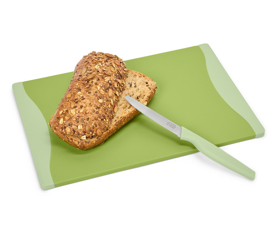 Chlieb a nôž na zelenej doske na krájanie.