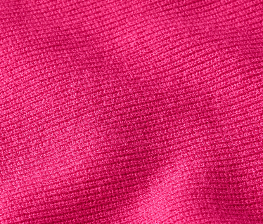 Detailný záber na textúru pleteniny v sýtej ružovej farbe.