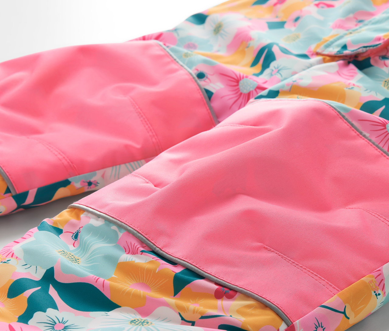 Detail kvetinových nohavíc s ružovými kolenami.