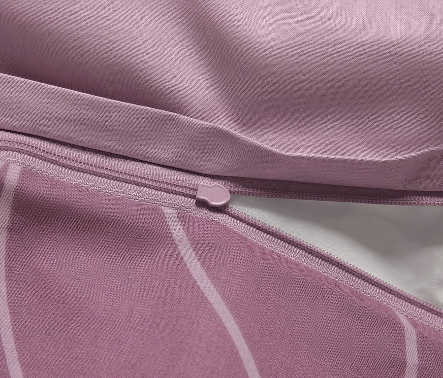 Detail fialovej obliečky na perinu so zipsom a bielym vnútrom.