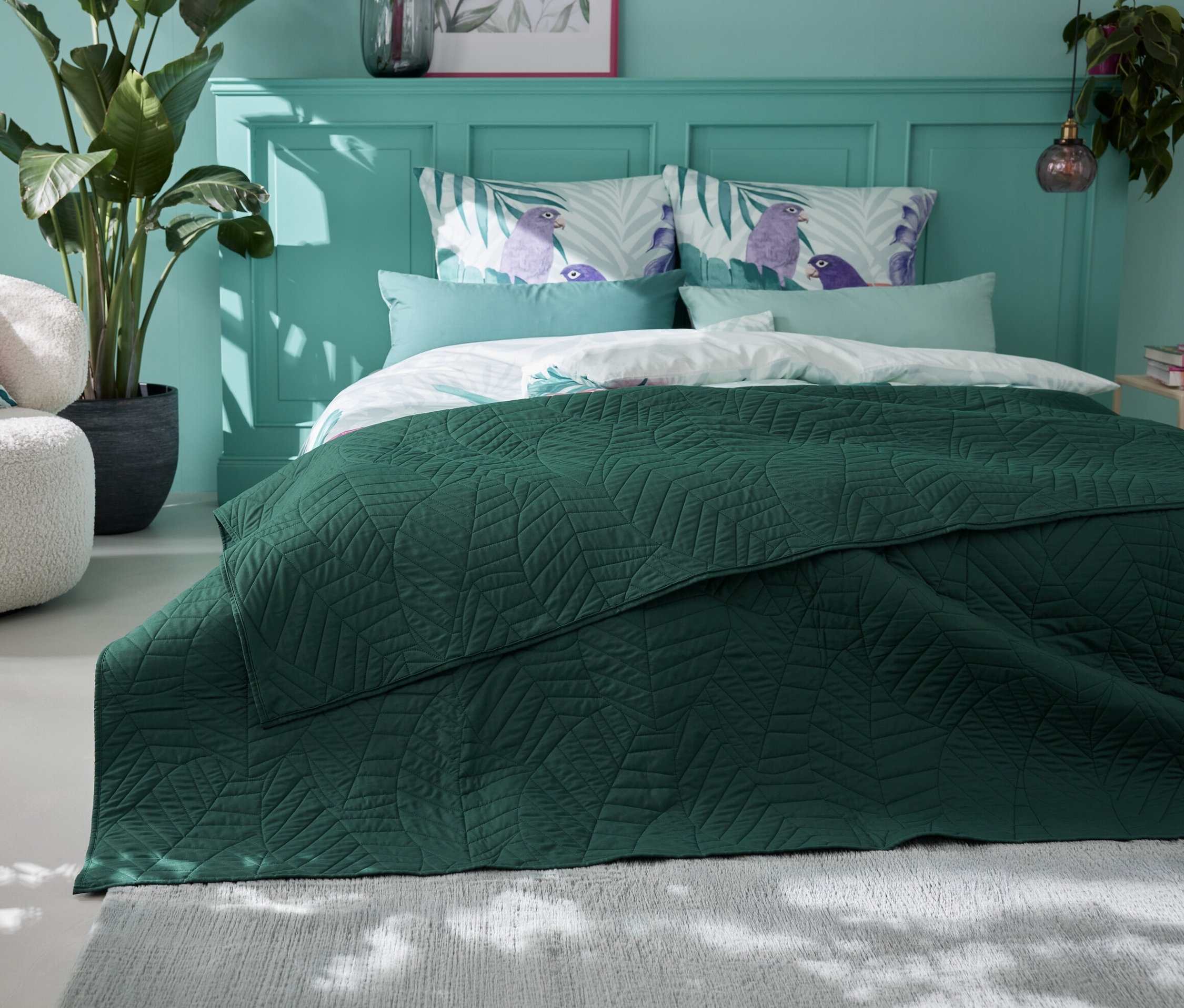 Zelený prešívaný prikrývka na posteľ (230 x 250 cm) leží na posteli v spálni.