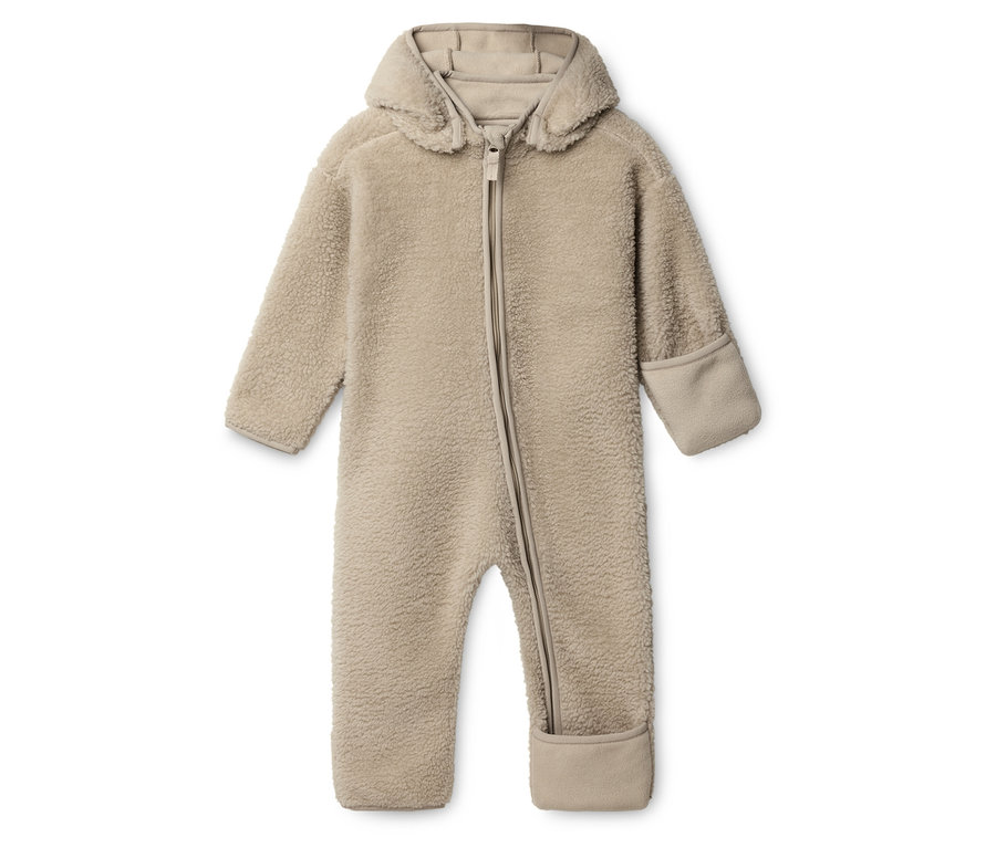 Béžový plyšový overal s kapucňou a zipsom leží na bielom pozadí.
