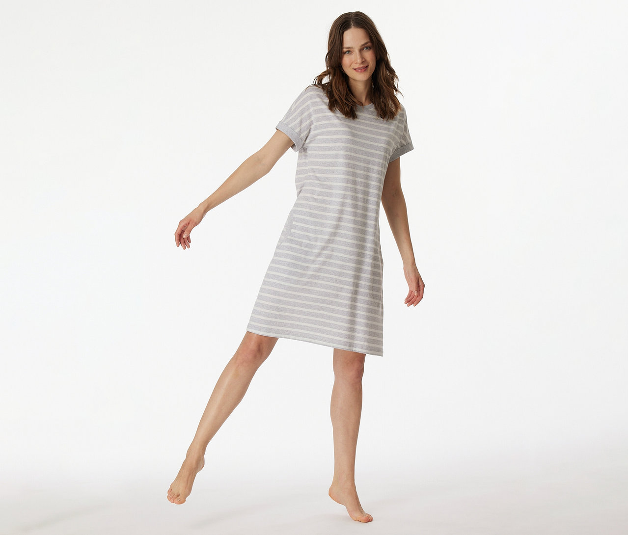 Žena v pruhované nočné košeli s krátkym rukávom SCHIESSER zdvíha nohu.