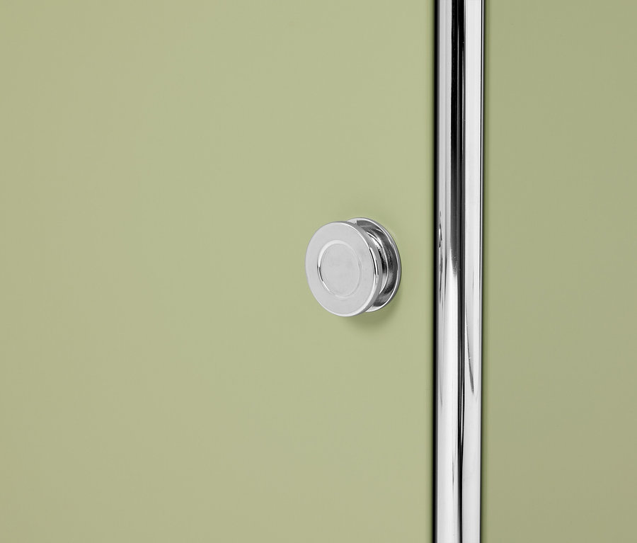 Detailný záber svetlozelených dverí skrinky s okrúhlym strieborným gombíkom a striebornou tyčou.