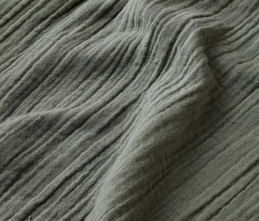 Detail záberu pokrčeného olivovozeleného materiálu.