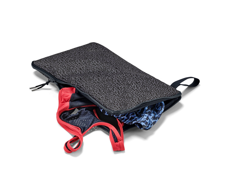 Otvorená podložka na prezliekanie a vrecko na mokré veci 2 v 1 s oblečením vnútri.