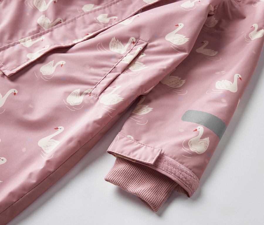 Detail detského overalu do dažďa s potlačou labutí.