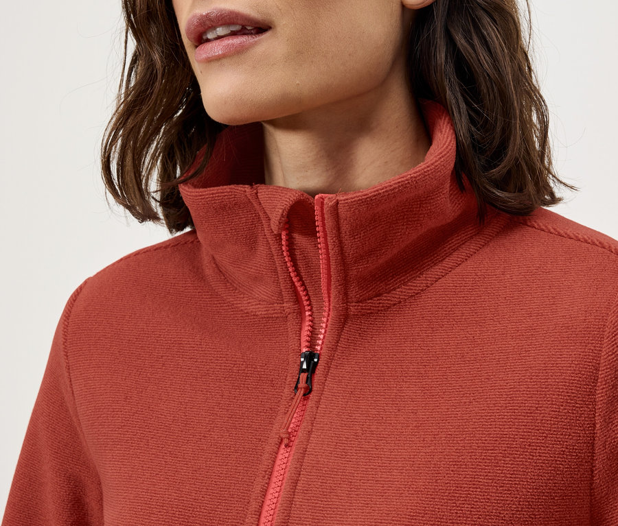 Detail dámskej fleecovej mikiny s golierom a zipsom.