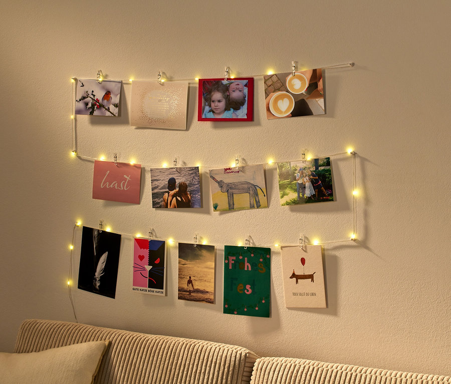 Fotografia zobrazuje LED svetelnú reťaz so svorkami, na ktorej visia fotografie.
