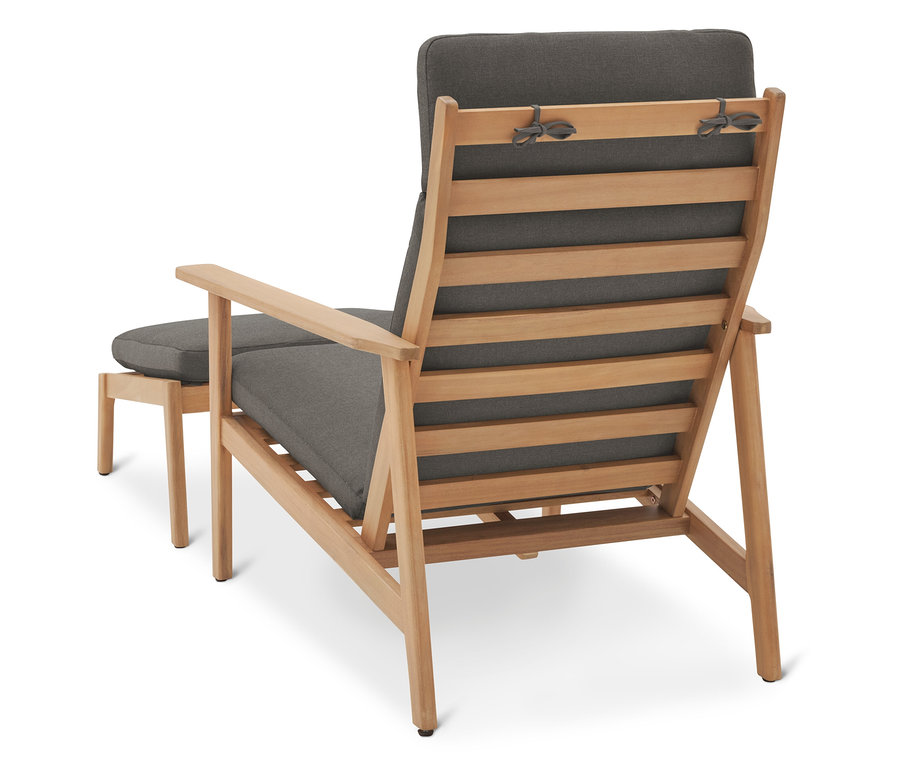 Pohľad zozadu na drevenú záhradnú stoličku so sivými vankúšmi a podnožkou.