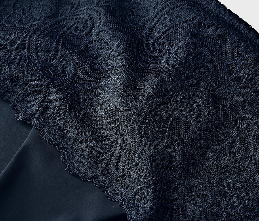 Detail modrej čipky na modrej látke.