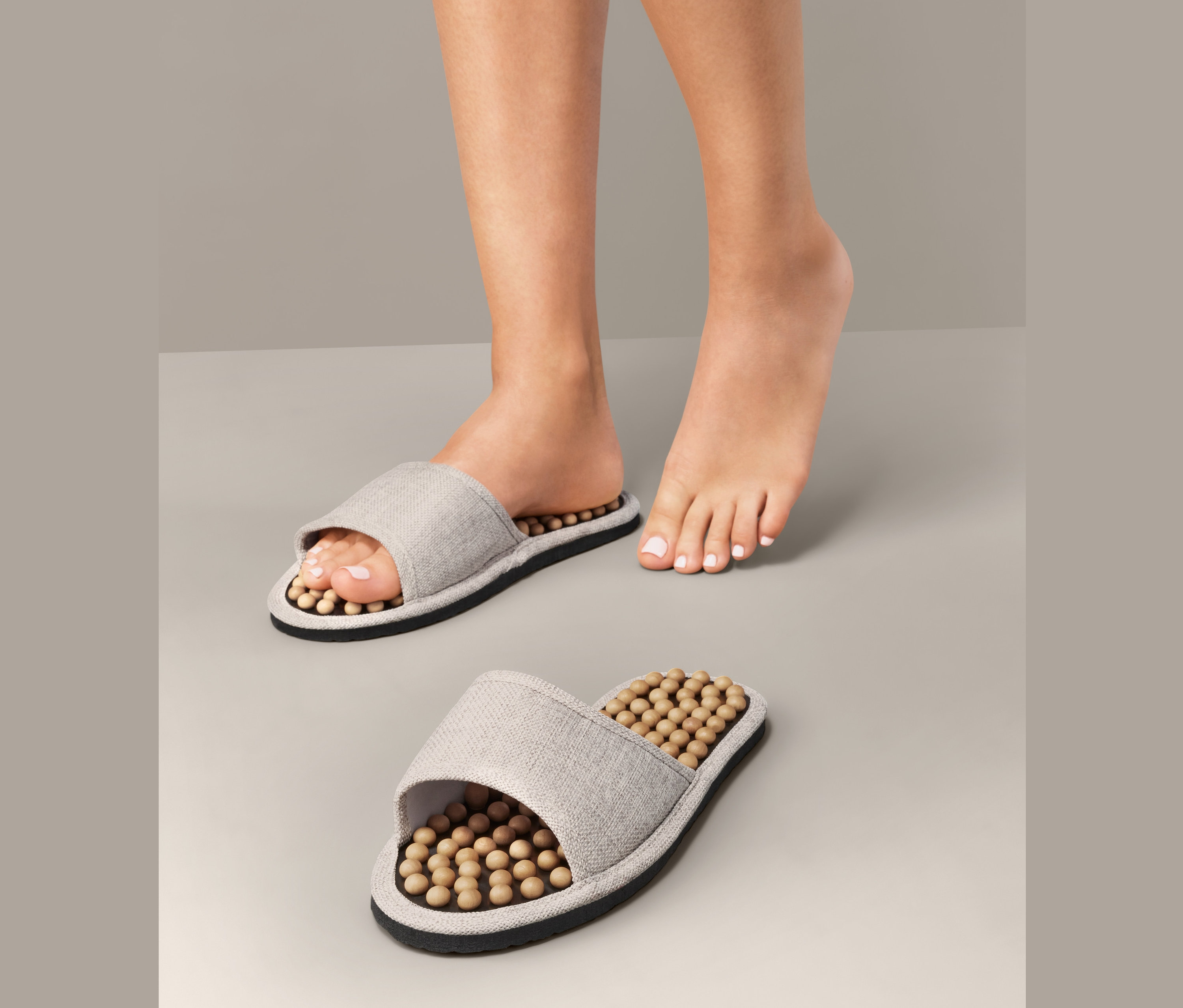 Noha v masážnej šľapke vedľa druhej šľapky.