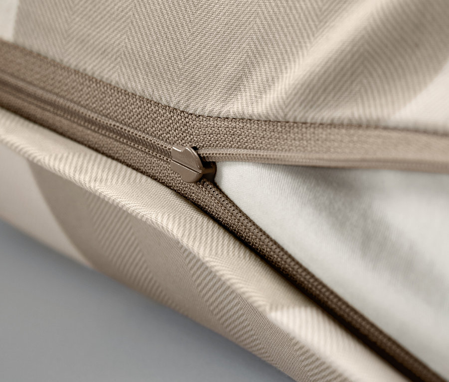 Detailný záber béžovej obliečky na vankúš so zipsom.