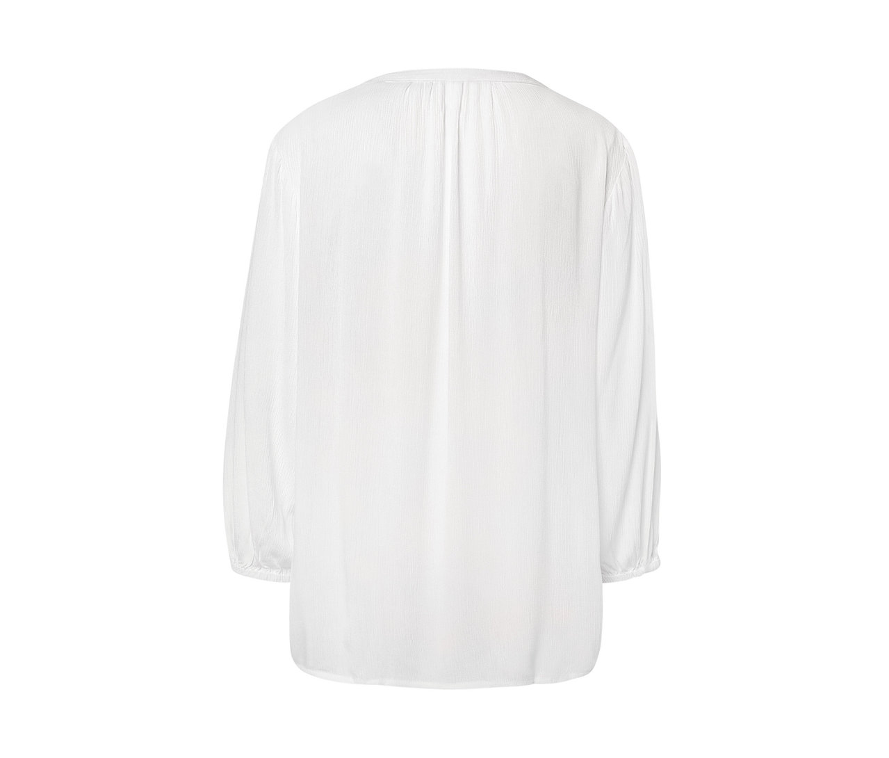 Detail bielej tunikovej blúzky.