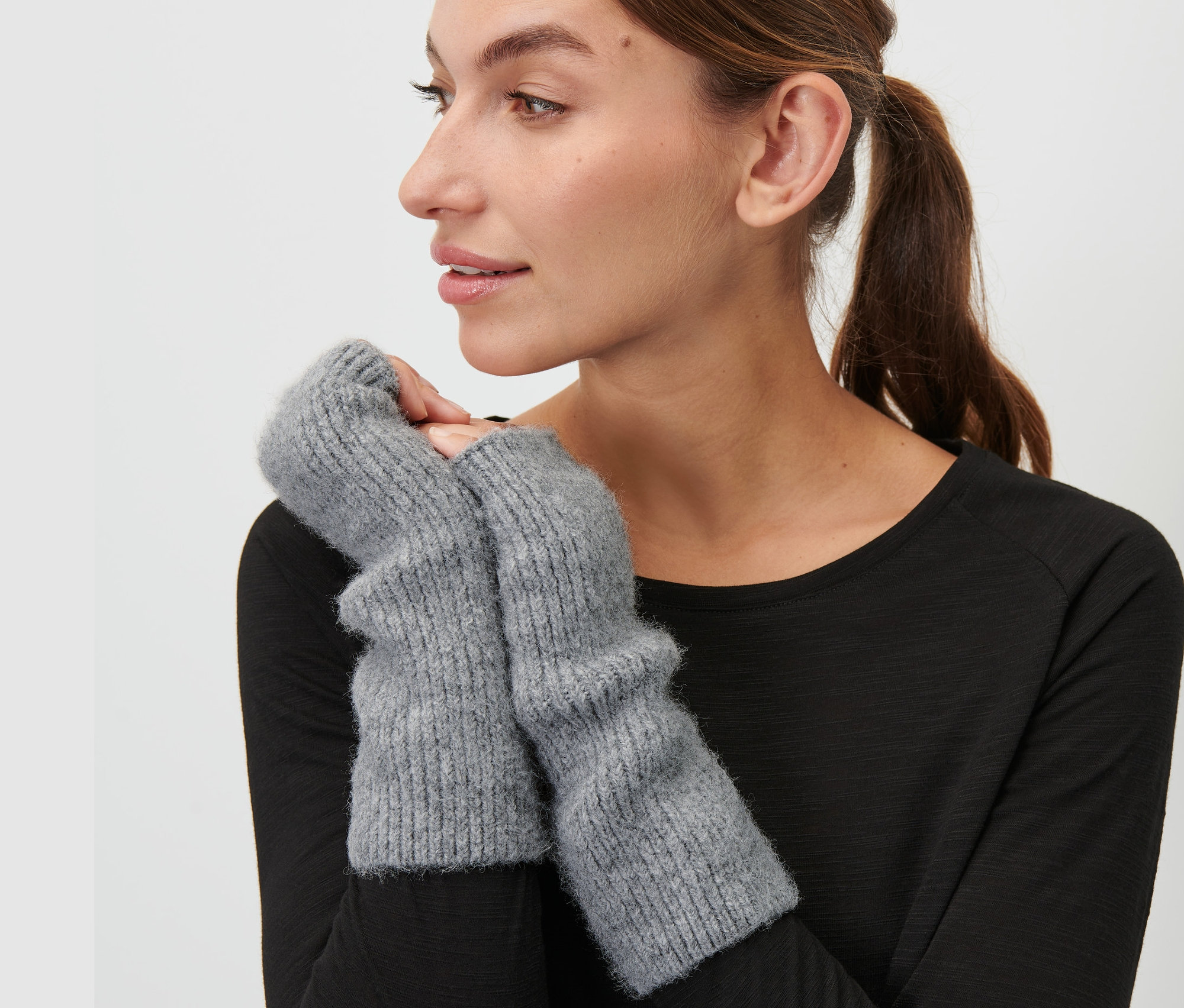 Žena má na sebe sivé návleky na ruky.