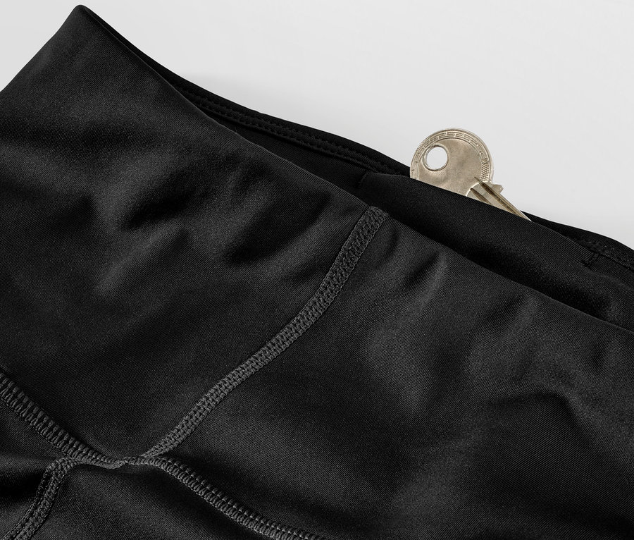 Detail čiernych športových legín s kľúčom vo vrecku.