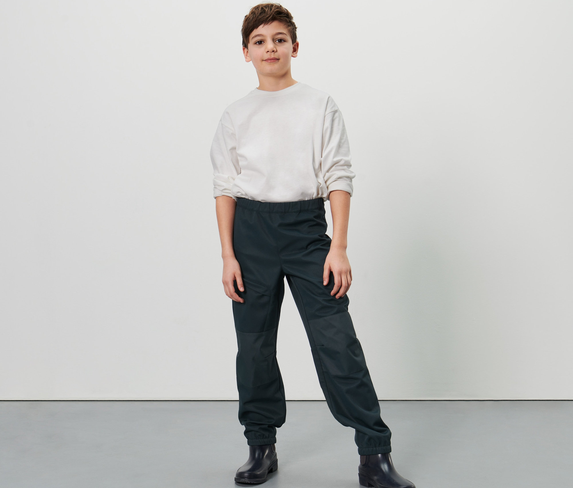 Chlapec pózuje v detských softshellových nohaviciach.