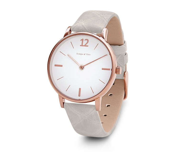 Detailný pohľad na náramkové hodinky s koženým remienkom s bielym ciferníkom a ružovo-zlatým puzdrom.