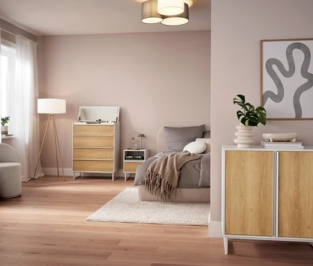 Spálňa so sivou stolovou LED lampou s akumulátorom na nočnom stolíku.