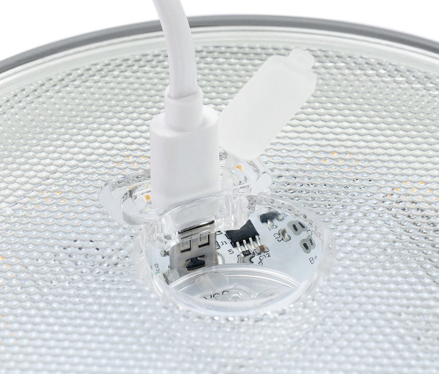 Detailný záber bieleho USB konektora zasunutého do priehľadnej zásuvky s viditeľnými elektronickými komponentmi.