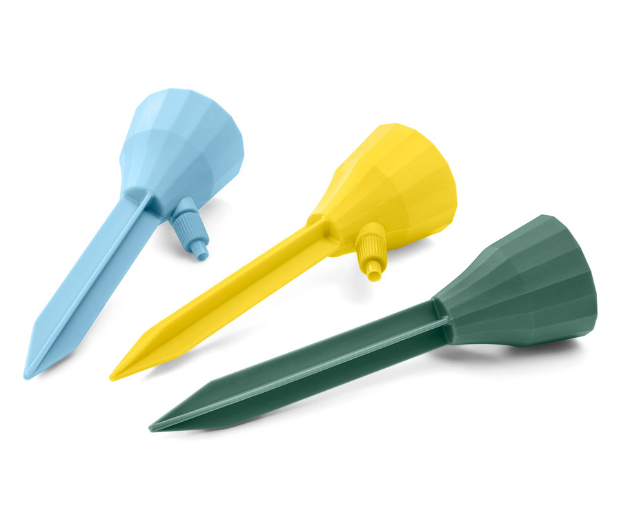Tri automatické zavlažovacie tyčinky v modrej, žltej a zelenej farbe ležia na bielom pozadí.