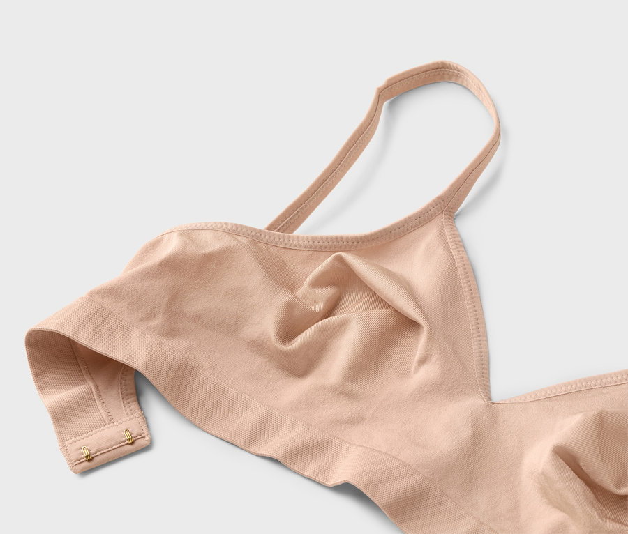 Detailný záber telovej podprsenky s tenkými ramienkami a zlatými háčikmi.