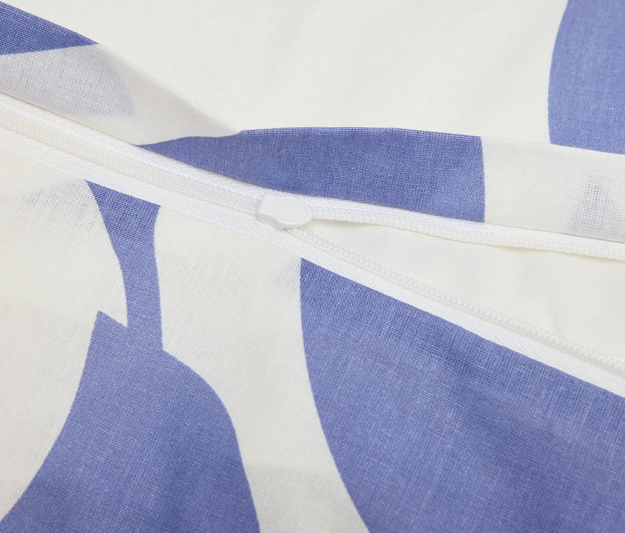 Detail zipsu na modro-bielej vzorovanej látke.