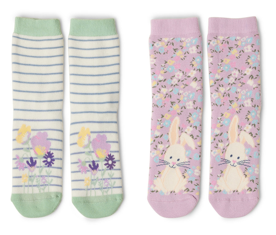 Dva páry ponožiek ležia na bielom pozadí. Jeden pár je pruhovaný s kvetmi a druhý je fialový so zajačikom.